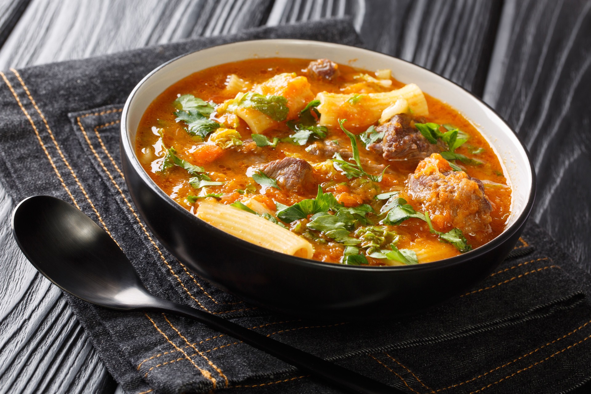 Soup joumou is a famous mildly spicy soup native to Haitian cuisine closeup in the plate. Horizontal